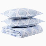 A stack of Eniya Azure Organic Duvet pillows by John Robshaw on top of each other. - 30395597586478