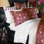 A bed with a Layla Sand Quilt by John Robshaw and a lamp. - 30403072196654