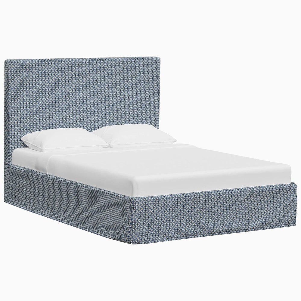 A Shona Bed with a blue upholstered headboard and footboard made with John Robshaw fabrics.