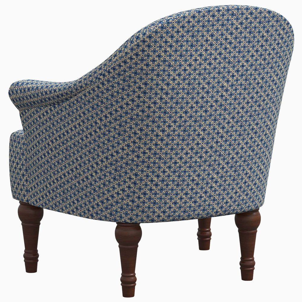 A John Robshaw Preeti Accent Chair with wooden legs.