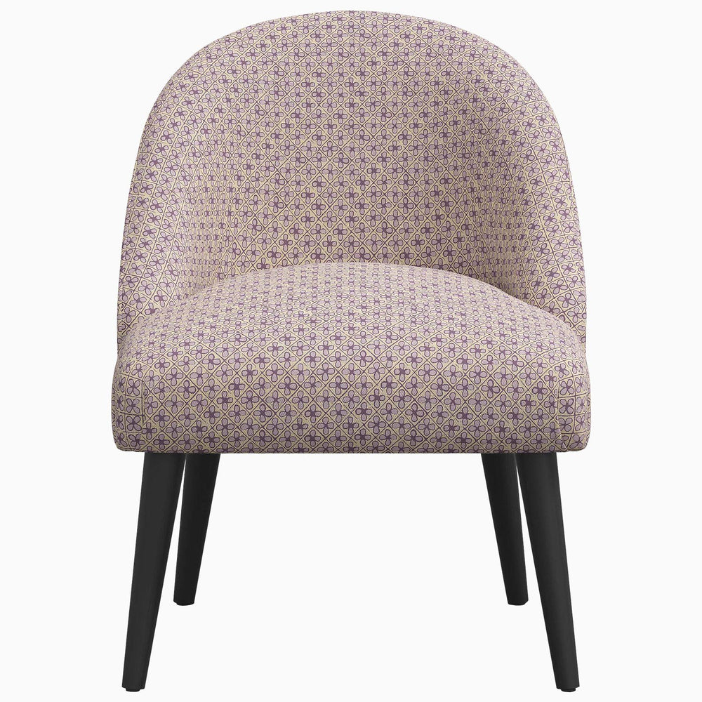 A Chetna Accent Chair by John Robshaw, a mid-century silhouette upholstered chair with black legs and prints inspired by John in Southeast Asia.