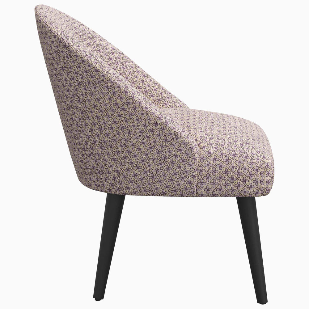 A Chetna Accent Chair by John Robshaw is a purple upholstered chair with a mid-century silhouette.