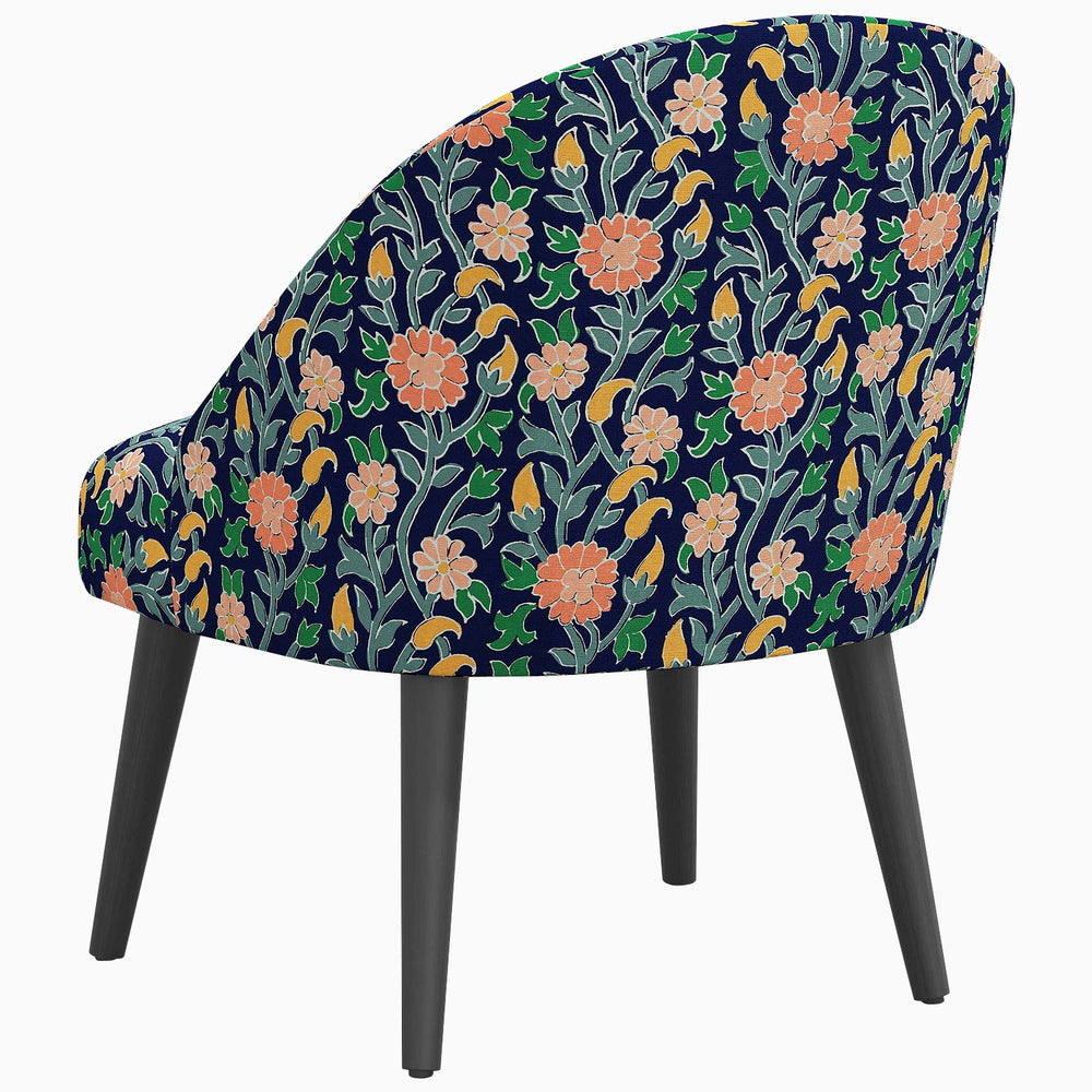 A Chetna Accent Chair with a mid-century silhouette and prints inspired by John Robshaw, featuring a floral pattern from Southeast Asia.