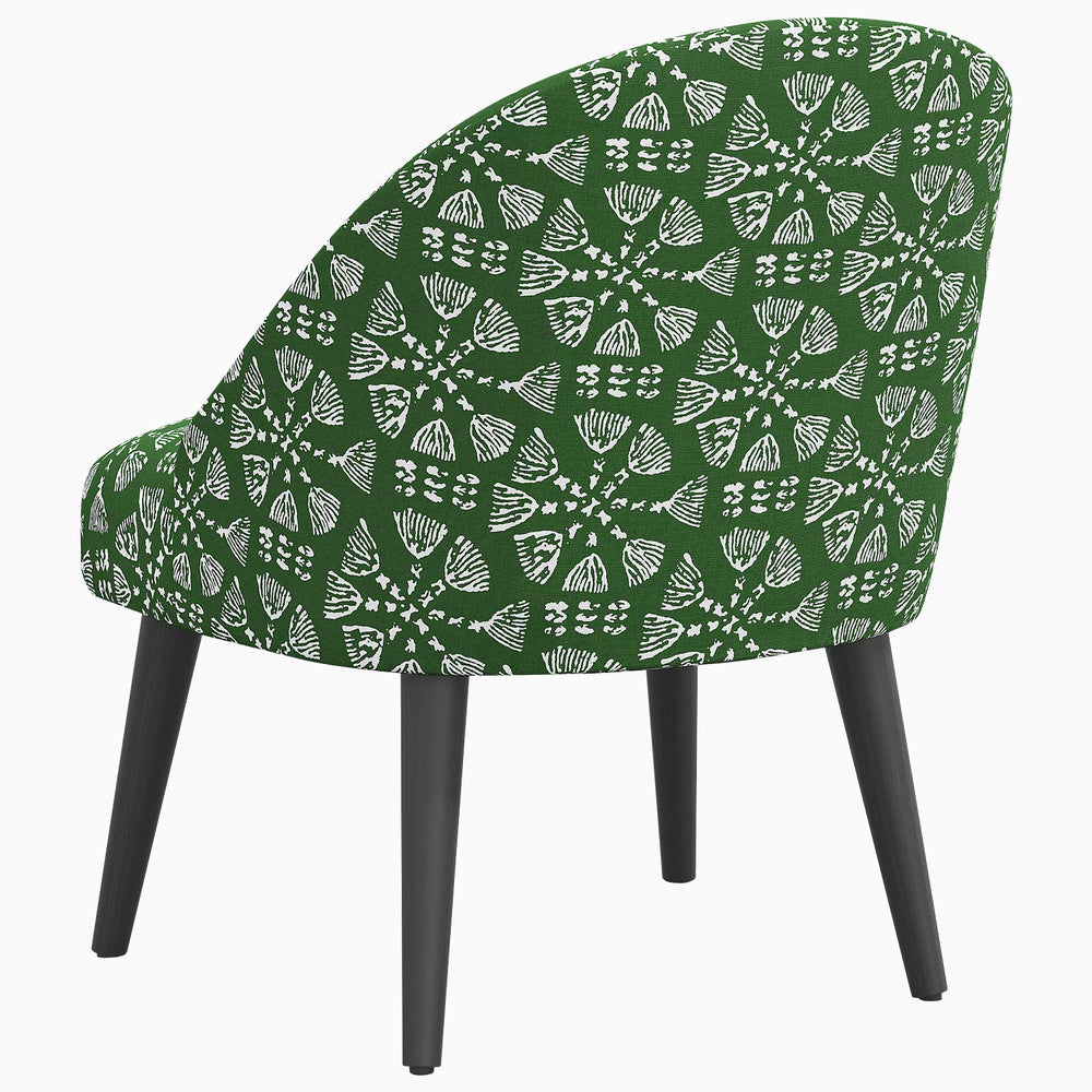 A Chetna Accent Chair by John Robshaw, with a green and white patterned design, mid-century silhouette, and black legs.