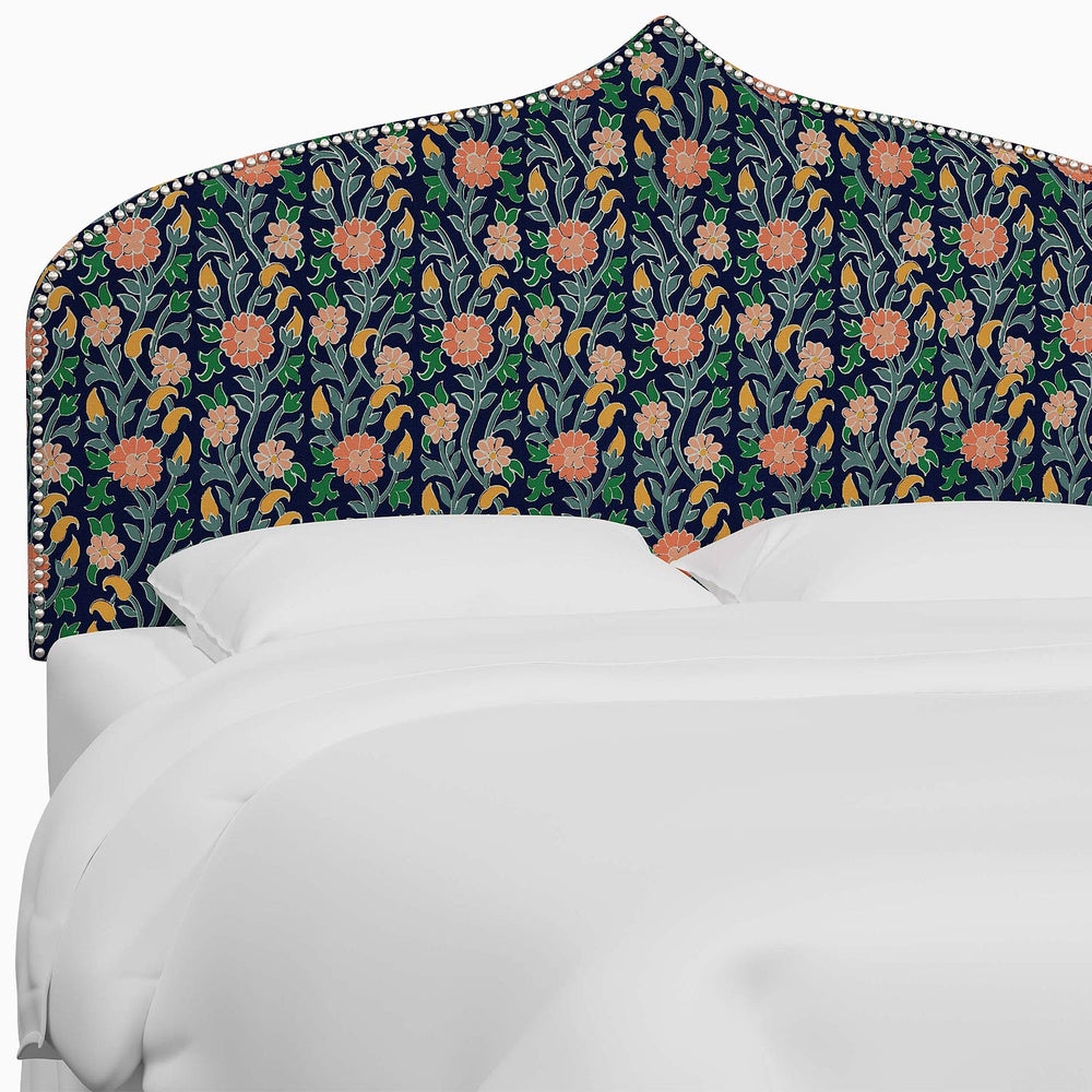 A bed with a floral John Robshaw Alina Headboard.