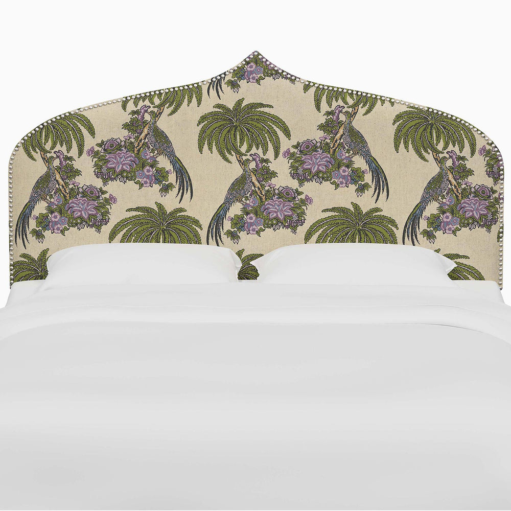 A bed with the John Robshaw Alina Headboard, featuring a vibrant purple and green bird print headboard with Mughal arches.