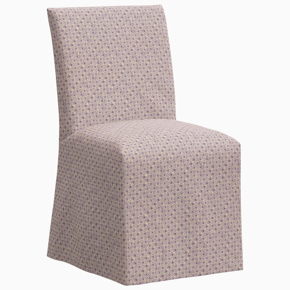 The John Robshaw Sadia slipcover chair is a stylish dining chair featuring a vibrant purple patterned fabric.