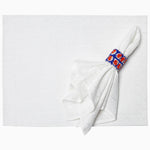 A John Robshaw hand-stitched white napkin with a red and blue ring on it made from cotton slub. - 29333306114094