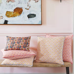 A Chetas Decorative Pillow by John Robshaw on a bench in front of a pink wall with a linen cotton blend throw pillow insert and a painting. - 30064586686510
