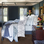 A bed in a bedroom with blue walls, adorned with a John Robshaw Kajal Gray Organic Duvet. - 30002972426286