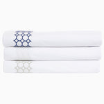 A stack of Sana White Organic Sheet Set made with organic cotton and featuring a geometric pattern, by John Robshaw. - 28739483500590
