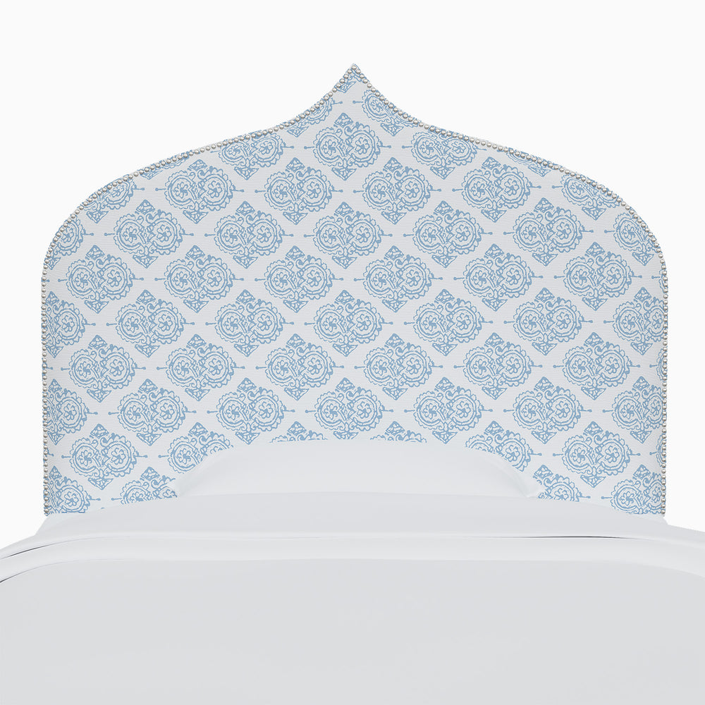A bed with an Alina Headboard by John Robshaw featuring Mughal arches.