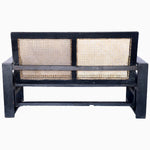 A modern John Robshaw black loveseat with curved arms and a rattan seat. - 29225383264302