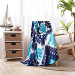 A Sashpura Indigo Beach Towel, hand-woven by John Robshaw, sitting on a chair in a room. - 29274371686446