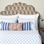 A floral bed with a blue and white patterned headboard made from a linen and cotton blend, suitable for machine wash cold, including the Oja Kidney Pillow by John Robshaw. - 30264084561966