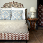 A Vivada Sand Woven Quilt by John Robshaw covers a bed in a cozy bedroom. - 30262782328878