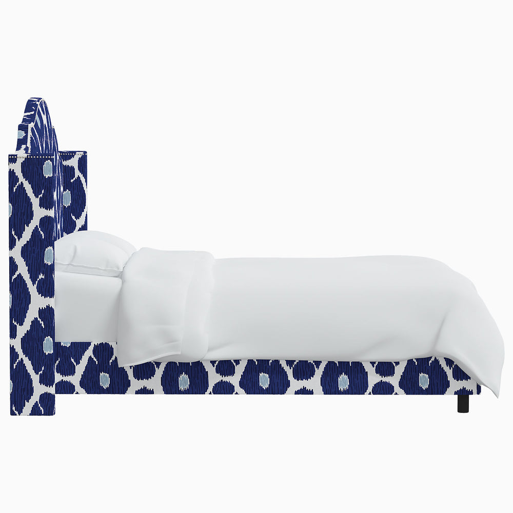 The John Robshaw Samrina bed is adorned with a stunning blue and white patterned headboard, reminiscent of Mughal arches.