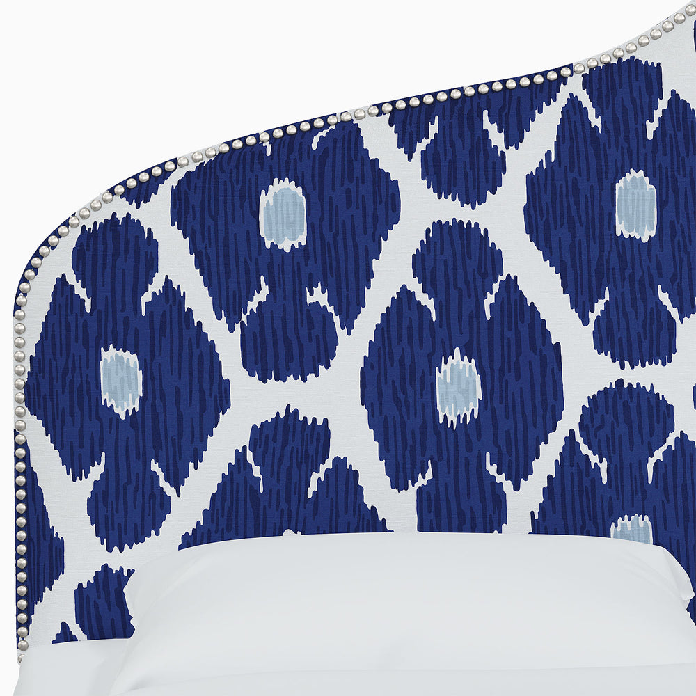 A bed with a blue and white John Robshaw Alina Headboard featuring Mughal arches prints.