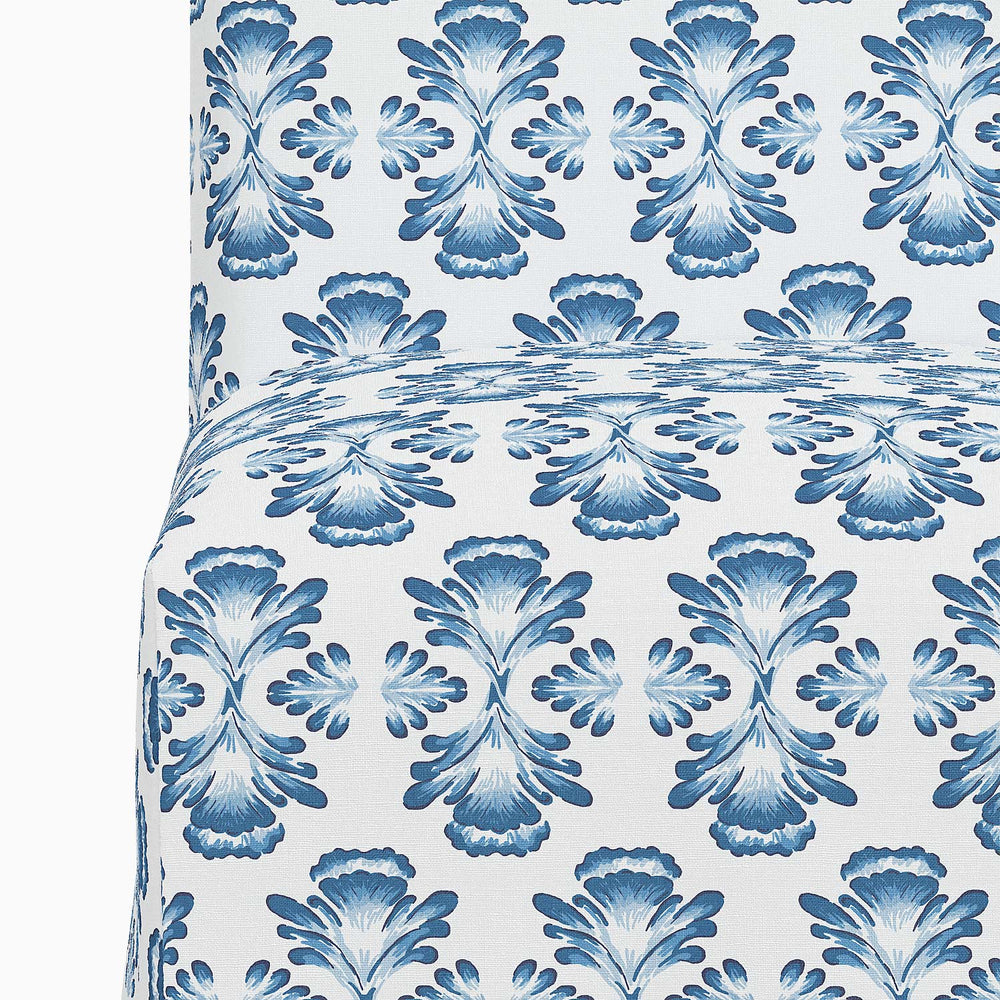 A John Robshaw Sadia Slipcover Chair in blue and white, featuring a floral pattern.