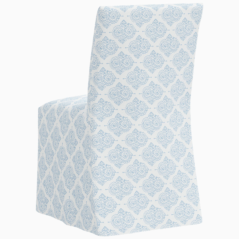The John Robshaw Sadia Slipcover Chair is a stylish dining chair boasting a blue and white damask pattern.