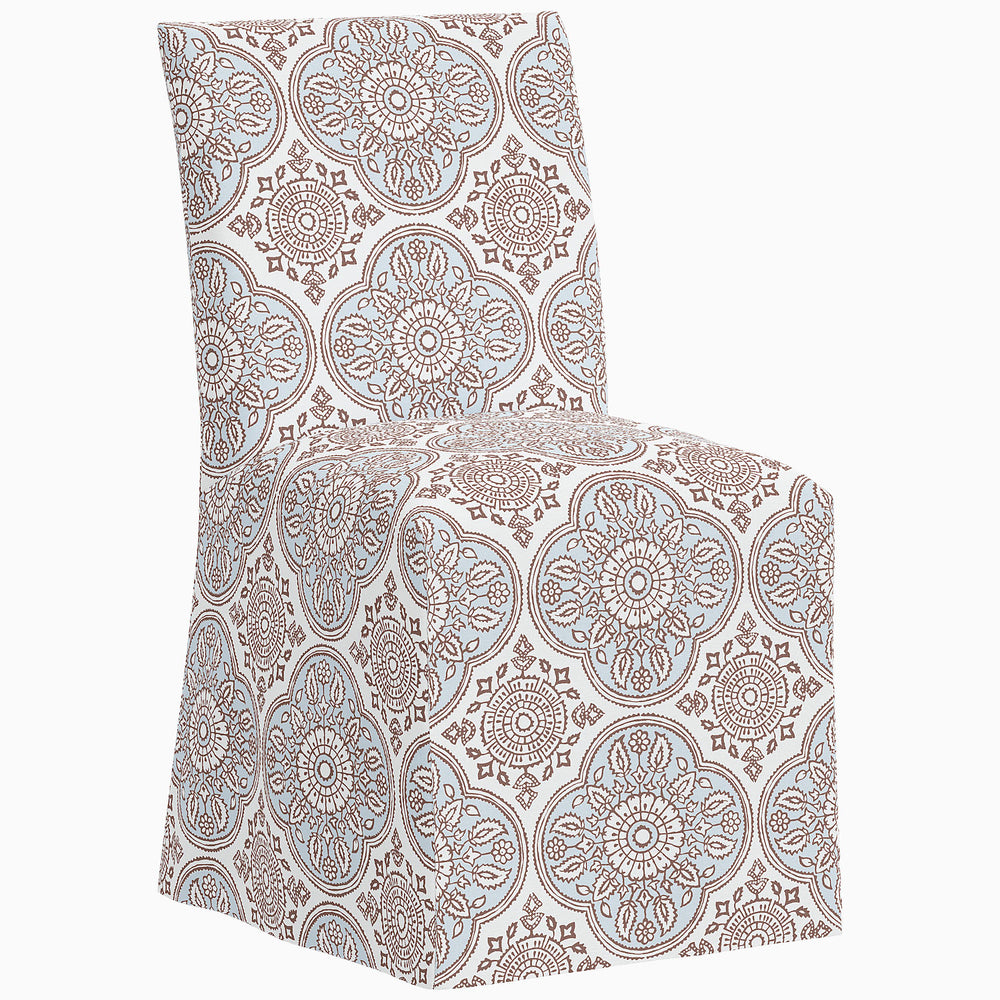 The John Robshaw Sadia Slipcover Chair is a stylish dining chair featuring a beautiful blue and white paisley pattern.