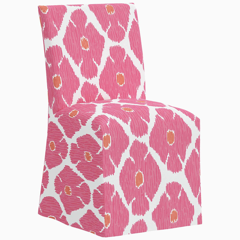 The John Robshaw Sadia Slipcover Chair is a pink dining chair with a pink and white pattern.