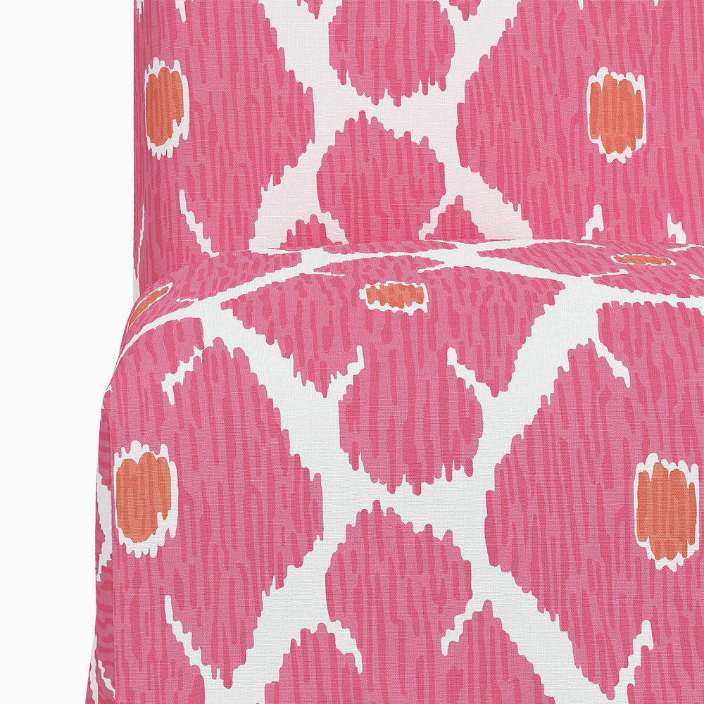 The John Robshaw Sadia Slipcover Chair is a vibrant dining chair with a beautiful pink and orange pattern.