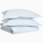A stack of John Robshaw Ramra Light Indigo Organic Duvets on top of each other. - 30252459622446