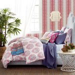 A pink and blue bedroom with a bed, pillows, and Vivada Indigo Woven Quilts by John Robshaw with hand stitching. - 4101489754158
