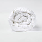 A John Robshaw down comforter rolled up on a white background featuring baffle box construction. - 2938688045102
