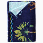 A Dhule Indigo Beach Towel with palm trees on it, perfect for Kenya safaris by John Robshaw. - 29274368344110