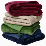 A stack of Velvet Berry Throws with tassels, hand-quilted by Indian artisans. - 30497693564974