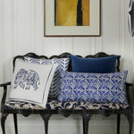 A blue and white Jiti Indigo Bolster hand stitched bench with pillows and a painting by John Robshaw. - 30403589177390