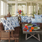 A living room with John Robshaw's Pihu Light Indigo Outdoor Bolster decorating a table and chairs. - 30404792057902