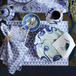 A blue and white table setting with plates featuring botanic block prints and raised metal utensils, adorned with John Robshaw's Gold Fern Napkin Rings (Set of 4). - 30405346263086