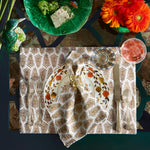 A table setting with plates, silverware, and John Robshaw Gold Fern Napkin Rings (Set of 4). - 30405346230318