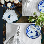 A hand-printed table setting with John Robshaw's Lia Silver Napkins (Set of 4) and blue and white plates. - 30405315723310