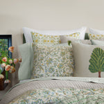 A bed adorned with green and yellow pillows, Tiya Periwinkle Woven Quilt, hand quilted and decorated with ornate vines from Quilts & Coverlets. - 30395682619438