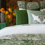 A hand-quilted bed with green and white bedding adorned with Pillows' Velvet Moss Decorative Pillow. - 30484742012974