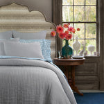 A bed with Gopan Peacock Organic Sheet Set by John Robshaw, in blue and white, featuring hand-stitched details and a window. - 30784336691246