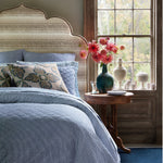 A John Robshaw Verdin Peacock Decorative Pillow adds a touch of elegance to the blue and white bedroom with a blue headboard. - 30801410326574