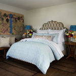 A bed in a bedroom with a John Robshaw Adesh Mist Duvet Set featuring a cotton jacquard fabric. - 30784318799918