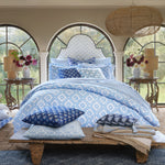A bedroom with the John Robshaw Nandi Light Indigo Quilt, blue and white bedding, and pillows. - 30783856607278