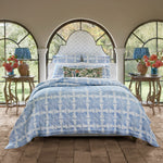 A unique blue and white bedroom with arched windows featuring the John Robshaw Jaya Azure Quilt and cotton voile decor elements. - 30784341377070