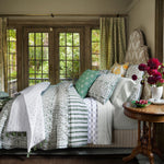 A bedroom with a green and white Janna Decorative Pillow and John Robshaw comforter featuring block printed patterns. - 30801457610798