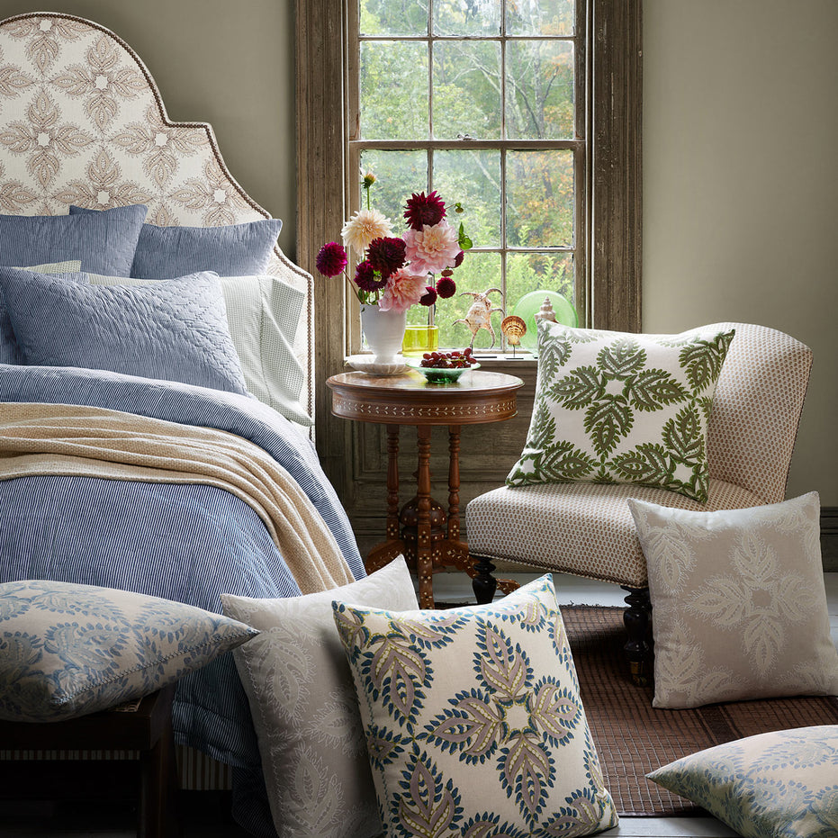 A bedroom with a hand block printed bedspread, John Robshaw Verdin Lapis Decorative Pillows, and a window.