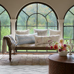 A John Robshaw Mirror Sand Decorative Pillow in front of a window featuring unbleached natural cotton linen and hidden zipper closure for added convenience. - 30801462427694