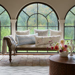 A bench with Verdin Sand decorative pillows in front of a window by John Robshaw. - 30801462460462