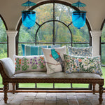 A bench with Bird Watcher Decorative Pillows from John Robshaw and hand painted blue lanterns in front of an arched window. - 30801467441198