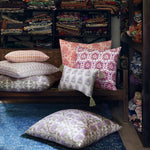 A room with a lot of John Robshaw Mizan Coral Kidney Pillows on a blue rug. - 30801470455854